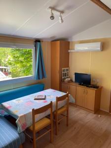 Habitación pequeña con mesa y ventana en Joli Mobil-home climatisé entièrement équipé, sauf draps en option, pour 4 adultes au maximum avec possibilité de 2 enfants en plus, en Sarlat-la-Canéda