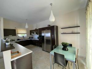 a kitchen with a table and a stainless steel refrigerator at Villa Kapsali in Kythira