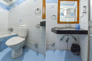 a bathroom with a toilet and a sink and a mirror at FabHotel Fly View in Jaipur