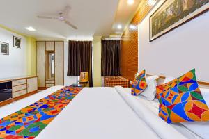 um quarto com uma cama grande e almofadas coloridas em FabHotel Fly View em Jaipur