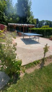 eine Tischtennisplatte im Hof mit Pavillon in der Unterkunft l'écureuil roux in Motteville