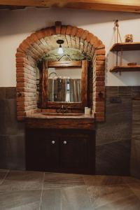 uma casa de banho em tijolo com um lavatório e um espelho. em Podklášterský domek em Trebic