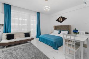 a bedroom with a bed and a couch and a table at RentForComfort Saint George Studio & Sea View in Mamaia
