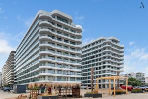 two tall white buildings in a parking lot at RentForComfort Saint George Studio & Sea View in Mamaia