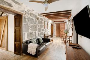 ein Wohnzimmer mit einer Couch und einer Steinwand in der Unterkunft La casa nueva in Fataga