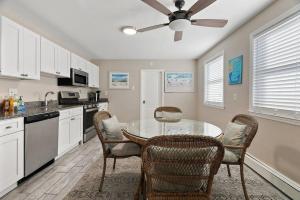 a kitchen with a table and chairs and a ceiling fan at 33rd Unit 1 Beachbound Parking 2 Blocks to the Beach in Brigantine