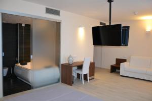 - un salon avec un canapé, une table et une télévision dans l'établissement Park Hotel Sant'Elia, à Fasano