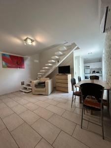 a living room with a staircase and a table and chairs at Babzsi Nyaraló in Vonyarcvashegy