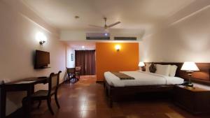 Habitación de hotel con cama, escritorio y ordenador en The Killians Boutique Hotel en Kochi