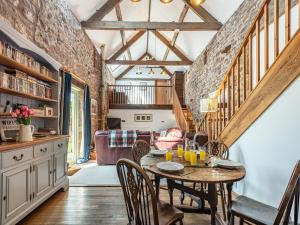 a kitchen and dining room with a table and chairs at Haytongate Barn in Walton