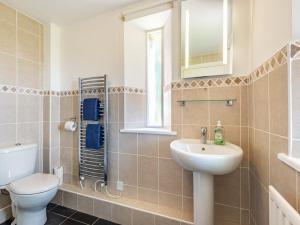 La salle de bains est pourvue d'un lavabo, de toilettes et d'un miroir. dans l'établissement Haytongate Barn, à Walton