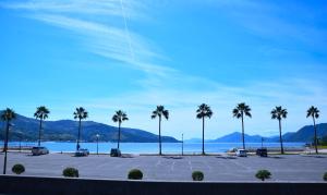 a parking lot with palm trees in front of the water at 伯方plus+ in Imabari