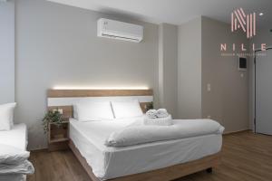1 dormitorio con 1 cama con 2 toallas en Ultima, Nilie Hospitality MGMT, en Tesalónica