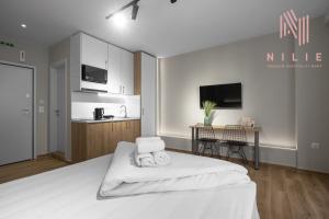 1 dormitorio con 1 cama blanca y cocina en Ultima, Nilie Hospitality MGMT, en Tesalónica