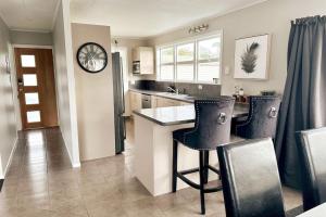 a kitchen with a counter and some chairs in it at The Tirau Cottage - Waikato in Tirau