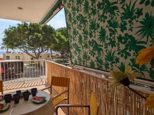 a table and chairs on a balcony with a wall at Terraza con vistas al mar Parking privado 120 mts, junto a la playa in Cullera