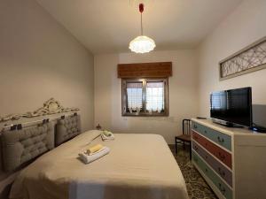 a bedroom with a bed and a flat screen tv at casa in spiaggia in Marina di Pescoluse