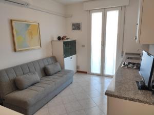 a living room with a couch and a kitchen at Appartamento CRISTALLO 25 in Lignano Sabbiadoro