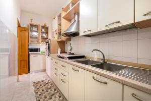 eine Küche mit weißen Schränken und einem Waschbecken in der Unterkunft Settebello House in Ceglie in Ceglie Messapica
