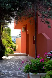 an orange building with flowers in front of it at Victoria in Plakias