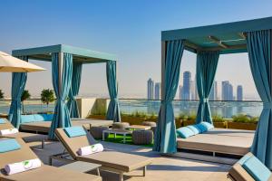une chambre d'hôtel avec des lits et des chaises dans l'établissement Element Al Jaddaf, Dubai, à Dubaï