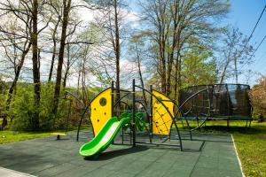 a playground with a slide in a park at Pensiunea Restaurant Vándor in Cîmpu Cetăţii