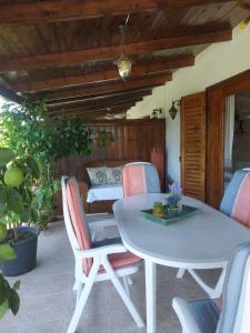 - une table et des chaises blanches sur la terrasse dans l'établissement Ivonnis Garden, à Mesimvría