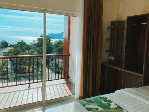 Schlafzimmer mit Blick auf einen Balkon mit einem Bett in der Unterkunft Sylvia Hotel & Resort Komodo in Labuan Bajo