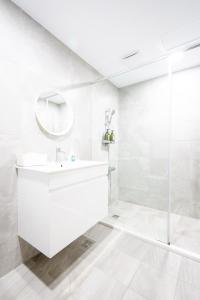 een witte badkamer met een wastafel en een douche bij Utopia Hostel in Taitung
