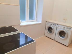 a kitchen with a washing machine and a window at Guest House Gorny Ruchei in Gagra