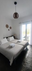 Enalia Studio في Korissia: غرفة نوم بيضاء مع سرير كبير عليه مناشف