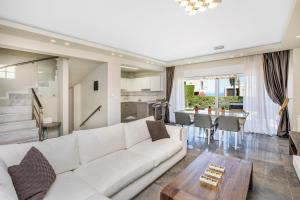un soggiorno con divano bianco e tavolo di Aegean Sea View Villa a Pefkohori
