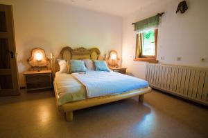 sypialnia z łóżkiem z niebieską pościelą i oknem w obiekcie Estate Žagmeštri w mieście Ljubno