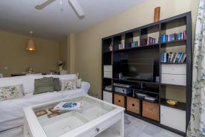 salon z białą kanapą i telewizorem w obiekcie Canovas Nerja - Alcazaba Parador, piscina, 2 dorm w mieście Nerja