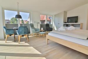 Schlafzimmer mit einem Bett, einem Tisch und Stühlen in der Unterkunft Lüttjeod - Apartment 11 in Langeoog