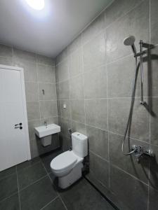 a bathroom with a white toilet and a shower at HeyShekvetili in Shekvetili