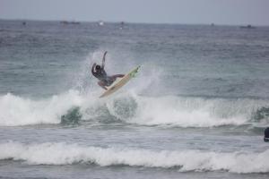 a man riding a wave on a surfboard in the ocean at Ayolah surf House and Surfcamp in Jembrana