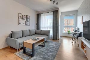 a living room with a couch and a table at Downtown Apartments City Center Bastion Wałowa in Gdańsk