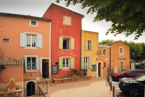 Une rangée de maisons colorées dans une rue dans l'établissement La Cerisaie, maison spacieuse en Lubéron, à Saint-Martin-de-Castillon