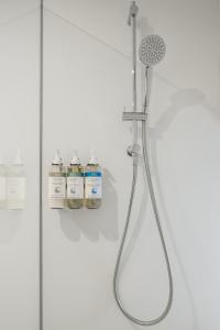 eine Dusche mit Duschkopf und 2 Flaschen Wasser in der Unterkunft numa I Molina Apartments in Sevilla