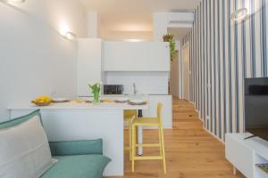 a kitchen with a white counter and a yellow stool at A Step from the Lake Apartment by Rent All Como in Como