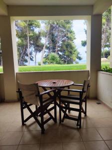 einen Tisch und Stühle in einem Zimmer mit Fenster in der Unterkunft Country Inn in Kallithea (Chalkidiki)