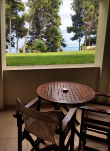 einen Tisch, zwei Stühle, einen Tisch und ein Fenster in der Unterkunft Country Inn in Kallithea (Chalkidiki)