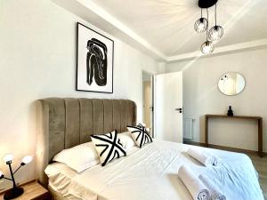um quarto com uma cama grande e almofadas pretas e brancas em A12 stylish and modern 2bds in La Marsa em La Marsa