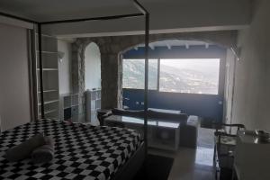 um quarto com uma cama xadrez e uma janela em Villa with unique & breathtaking view over Sea, Monte-Carlo, Italy & Alps em La Turbie