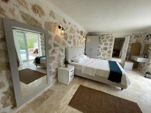 a bedroom with a large bed and a mirror at Bezirgan Inn Kalkan in Islamlar +17 photos