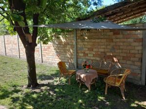 una mesa y sillas bajo una sombrilla en un patio en Apartman Woolf, en Senta