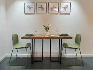 布雷西亞的住宿－SG9 CITY APARTMENTS，餐桌、两把椅子和一张鲜花桌