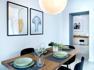 a dining room with a wooden table with plates at SG9 CITY APARTMENTS in Brescia