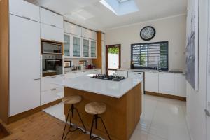 a kitchen with white cabinets and a clock on the wall at Albert Road 14 in Cape Town